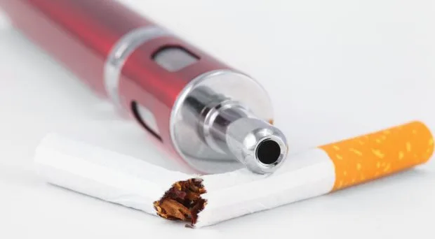Conceptual image of a broken cigarette next to a modern vape device symbolizing the industry struggle in Indonesia.